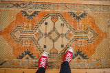 Distressed vintage Oushak rug runner featuring bold geometric patterns in tangerine and slate blue.