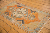Distressed vintage Oushak rug corner with tangerine field, seafoam and navy geometric patterns.
