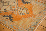 Distressed vintage Oushak runner corner, revealing worn tangerine orange, seafoam, and slate blue motifs.
