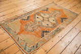 Distressed tangerine orange Oushak rug corner with patterned seafoam spandrel and geometric border.