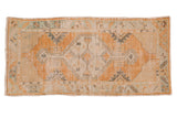Distressed Oushak runner, tangerine and ivory diamond medallion, soft mint accents, even wear.