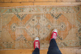 Distressed Oushak rug runner with worn tangerine orange and ivory diamond medallion.