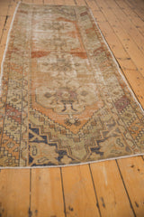 Vintage Distressed Oushak rug corner with truncated barber pole border and faded floral designs.