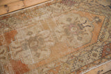Distressed Oushak runner's textured pile showing muted terracotta and ivory tones.