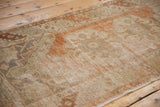 Distressed vintage Oushak runner pile with faded terra cotta and antique ivory floral motifs.