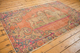 Distressed vintage Oushak rug showing pictorial lions, faded rose, blush, and denim blue.