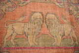 Distressed Oushak rug, pictorial tan lions on faded orange field with soft wear.