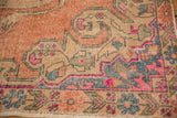 Distressed Oushak rug showing faint foundation, blush, blue, and terracotta patterns.