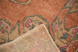 Distressed Oushak rug pile showing wear to knot heads, pink hues, and hand-knotted reverse.