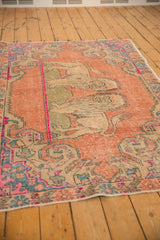 Distressed Oushak rug's faded texture with pictorial lions in rose, ivory, and blue.