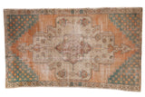Distressed vintage Oushak rug with faded terra cotta, ivory medallion with geometric palmettes, teal corners 4'4