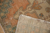 Distressed vintage Oushak rug detail with exposed foundation and geometric patterns.