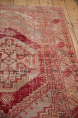 Distressed Oushak rug showing cherry red, beige stepped medallion and serrated leaf motifs.
