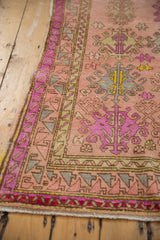 Distressed Oushak runner detail: vibrant pink, mint, and blush floral and geometric patterns.