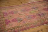 Distressed Oushak runner close-up, showing faded dusty rose, florescent purple, mint floral patterns.