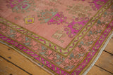 Oushak runner corner showcasing distressed texture, vibrant fluorescent purple border, and pastel motifs.