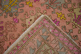 Vintage Distressed Oushak rug with dusty rose floral guls and visible hand-knotted foundation.