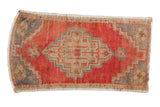 Distressed vintage Oushak rug mat: cherry red field, beige stepped medallion, aqua accents.