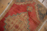 Distressed Oushak rug detail: low pile texture, cherry red, beige, and aqua geometric patterns.