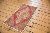 Distressed red Oushak rug corner showing even wear to knot heads and geometric pinwheel.