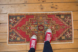Vintage distressed Oushak rug featuring cherry red, charcoal, dusty gold, and worn texture.