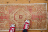 Textured distressed Oushak rug pile with blush, beige, saffron hues, and even wear to knot heads.