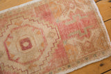 Distressed blush, ivory, and saffron geometric motifs on the hand-knotted Oushak rug.