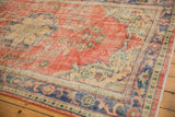 Vintage Distressed Oushak detail: brick red, royal blue, ivory floral vines, mostly even wear.