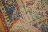 Distressed Oushak rug corner revealing hand-knotted pile, reverse foundation, and woven selvedge.