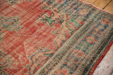Distressed vintage Oushak rug detail, showing brick red abrash, blue-green motifs, mostly even wear.