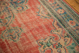Vintage Oushak rug showing distressed brick red, denim blue, and mostly even wear.