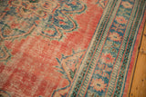Distressed texture of a vintage Oushak rug, highlighting brick red field and blue-green border.