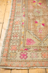 Worn pile on distressed Oushak rug runner side, with colorful pinwheel motifs.