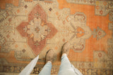 Textural distressed Oushak rug runner with muted tangerine, ivory, and beige patterns.