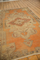 Distressed tangerine and beige Oushak runner texture with geometric vinery and budded flowers.