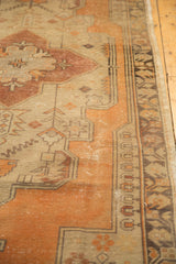 Distressed Oushak runner with tangerine orange field, faded pile, and geometric beige border.