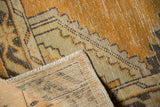 Hand-knotted Oushak rug reverse with secured fringe and distressed gold pile.