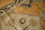 Distressed vintage Oushak rug showing worn dusty gold field, exposed knot heads, and beige patterns.