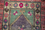 Distressed Oushak rug detail: purple stepped design, fuchsia accents, and heavily abrashed texture.