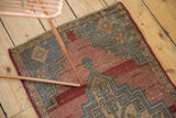 Vintage distressed Oushak rug detail showing mostly even wear, pale red, and geometric design.