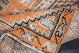 Distressed hand-knotted Oushak runner texture, tangerine, silver geometric patterns.