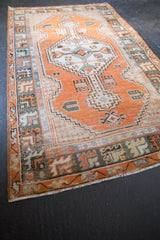 Distressed Oushak runner corner with geometric border, faded tangerine, silver tones.
