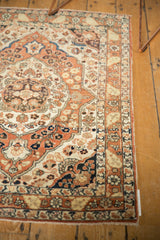 Angled corner view of an antique Haji Jalili Tabriz rug, showing the intricate floral medallion and rust-colored border.
