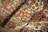 Folded view of an antique Tabriz rug highlighting the intricate floral weave and soft, low pile.