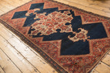 Contoured ivory medallion and bold red geometric border on an antique Malayer rug.