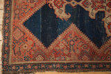 Corner of an antique Malayer rug, showing sharp border contouring, abrashed dark indigo field, and rich patina.