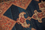Vivid red and ivory finial detail on an abrashed dark indigo blue Antique Malayer rug.