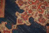 Antique Malayer rug's indigo field with rich patina and bold red, ivory curvilinear motifs.