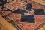 Worn abrashed indigo field, ivory medallion, and red geometric border of an antique Malayer rug.