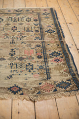 Hard-worn beige field with navy blue and blush geometric designs on an antique Caucasian rug.